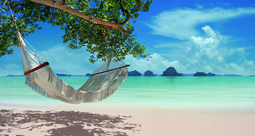 Relaxing hammock on pristine Thai beach with turquoise water and limestone islands